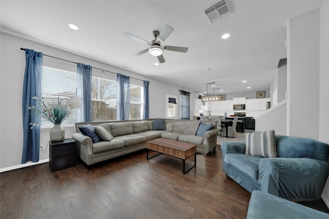 living room with ceiling fan and dark wood-type flooring