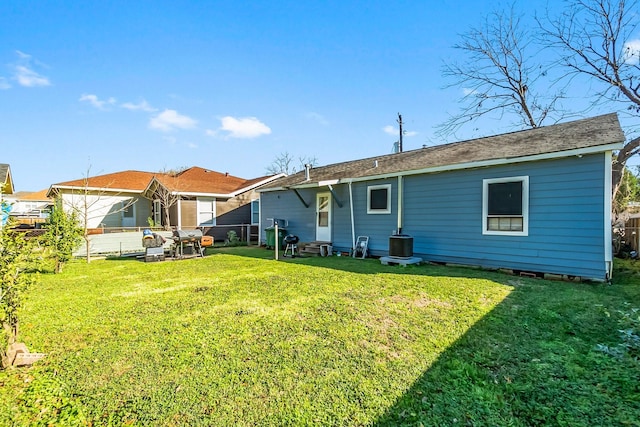 back of house featuring a lawn and cooling unit