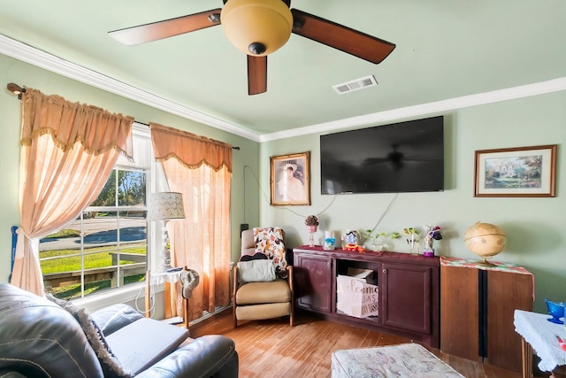 living area with light hardwood / wood-style floors and crown molding