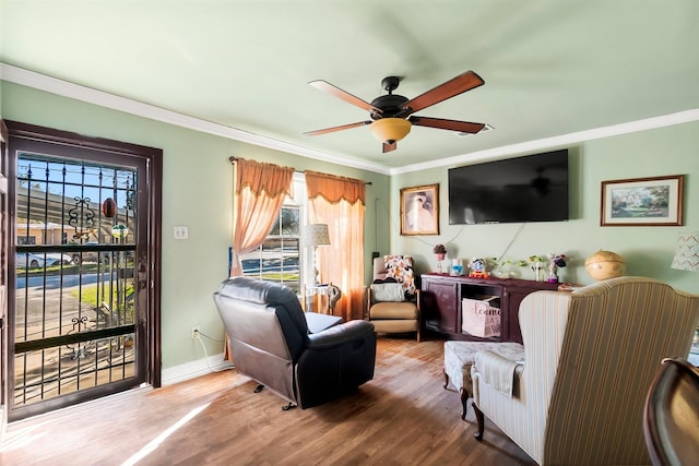 living area with hardwood / wood-style floors, ceiling fan, and ornamental molding