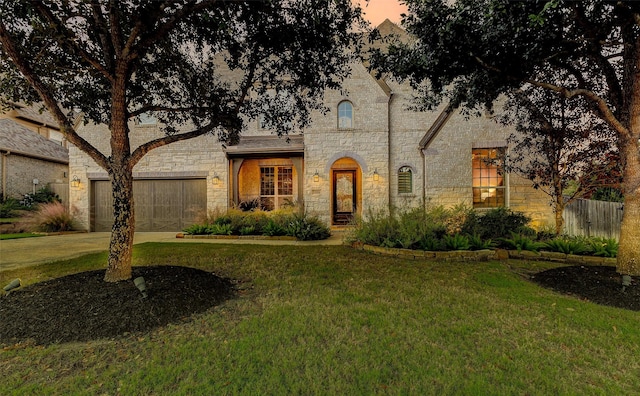 view of front of property with a yard and a garage