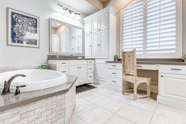 bathroom with tile patterned floors, vanity, and tiled bath