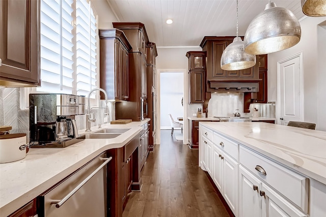 kitchen featuring backsplash, sink, pendant lighting, dishwasher, and white cabinets