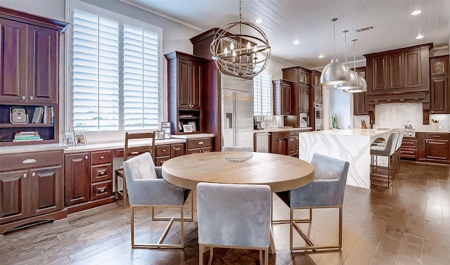 dining space with light wood-type flooring, wood ceiling, crown molding, sink, and a notable chandelier