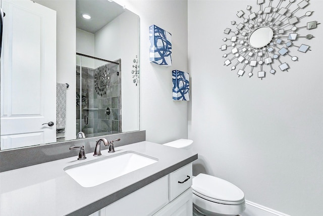 bathroom with a shower with door, vanity, and toilet