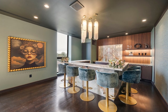 bar featuring hanging light fixtures and dark wood-type flooring