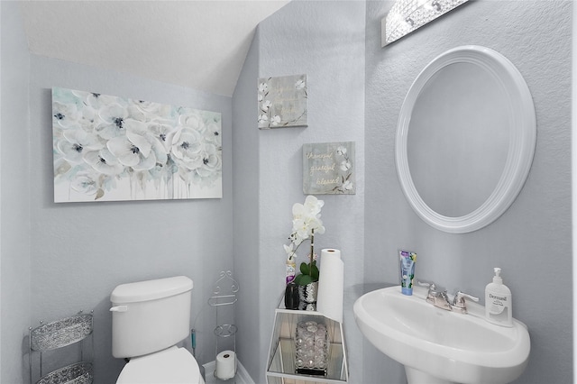 bathroom with sink, lofted ceiling, and toilet