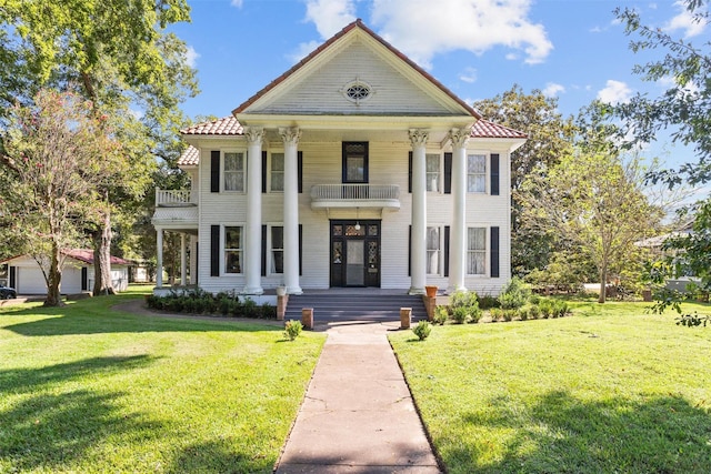 greek revival house with a balcony and a front lawn