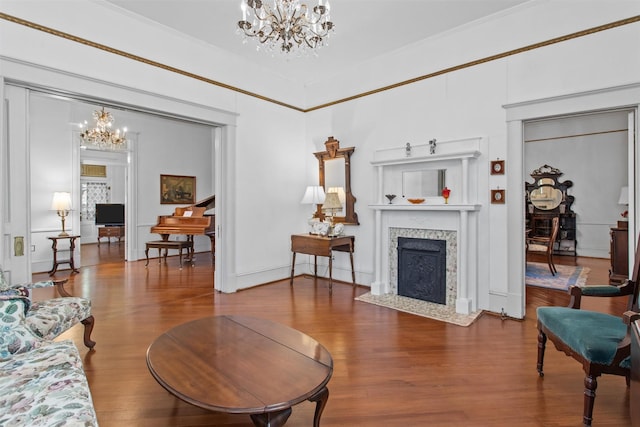 living room with hardwood / wood-style floors, a high end fireplace, and a notable chandelier