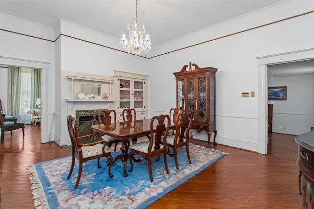 dining room with wood-type flooring, crown molding, and an inviting chandelier