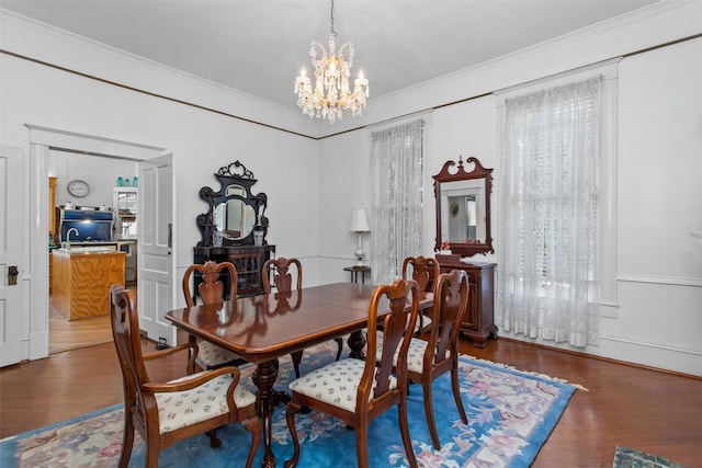 dining area with a chandelier, hardwood / wood-style flooring, and crown molding