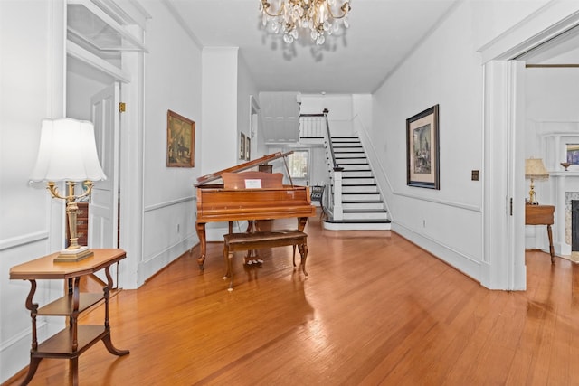 miscellaneous room with wood-type flooring, an inviting chandelier, and crown molding