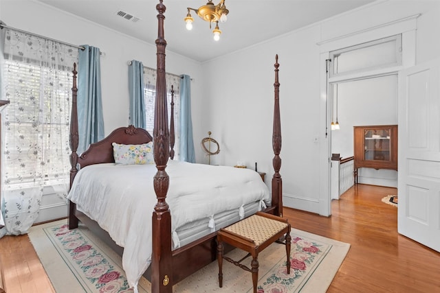 bedroom with light wood-type flooring and crown molding