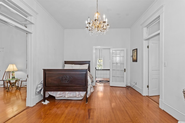 bedroom with crown molding, hardwood / wood-style floors, and a chandelier