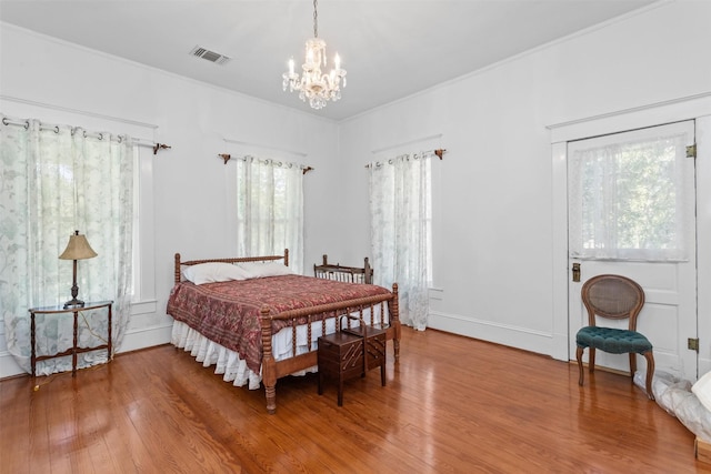 bedroom with hardwood / wood-style floors and a notable chandelier