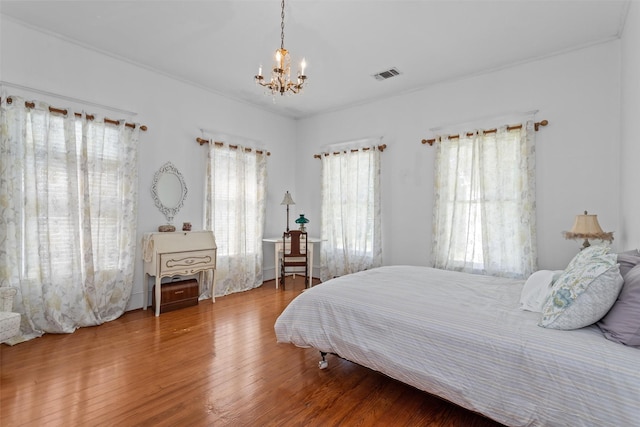 bedroom featuring hardwood / wood-style floors and an inviting chandelier