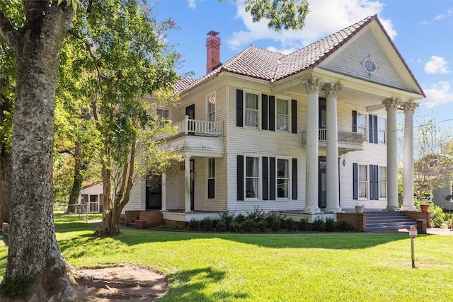 view of front of property with a balcony and a front lawn