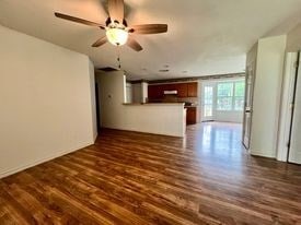 unfurnished living room featuring ceiling fan and dark hardwood / wood-style flooring