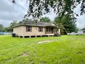 rear view of property with central AC, a yard, and a deck