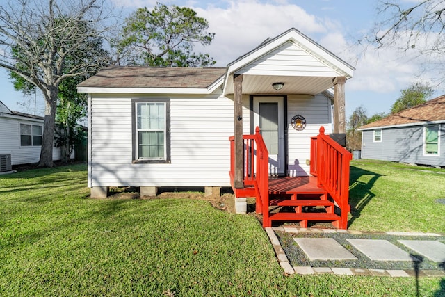 bungalow-style home featuring central AC unit and a front yard