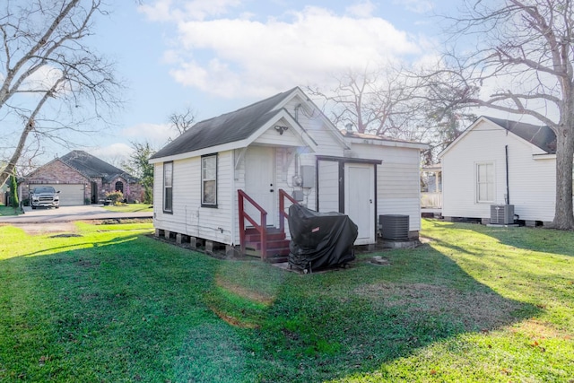 view of outdoor structure with a lawn and central AC