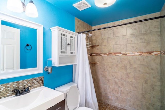 bathroom with decorative backsplash, vanity, toilet, and curtained shower