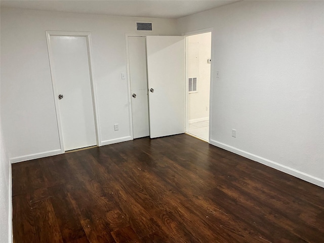 unfurnished bedroom featuring dark hardwood / wood-style flooring