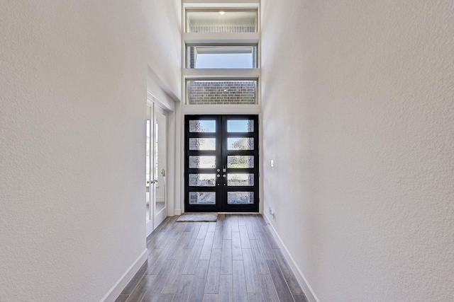 doorway with a high ceiling, dark hardwood / wood-style flooring, and french doors