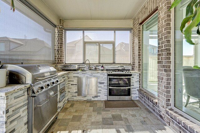 view of patio with an outdoor kitchen, sink, and a grill