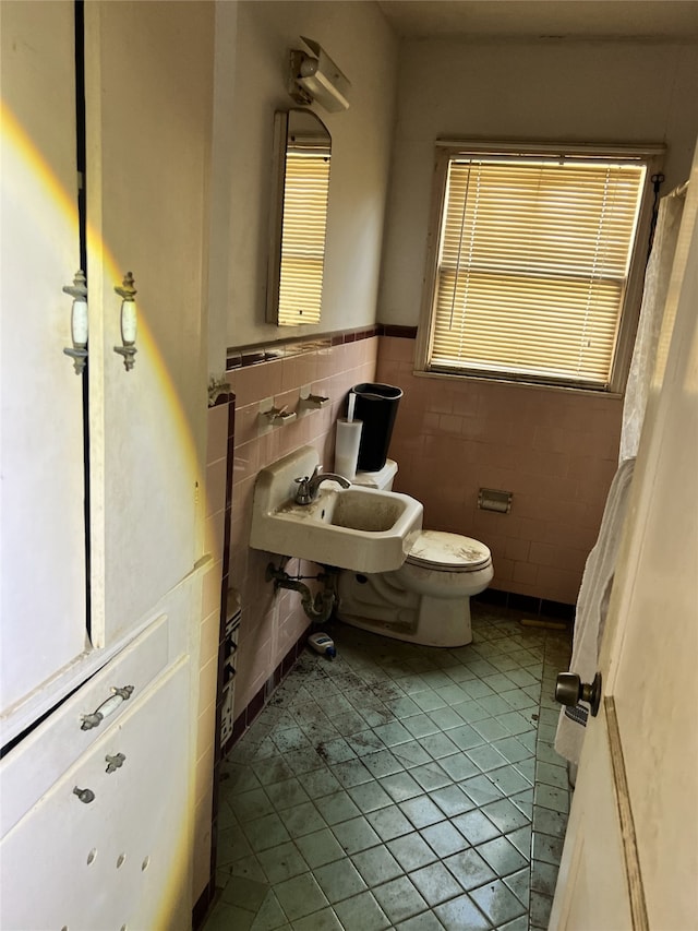 bathroom featuring tile patterned floors, sink, tile walls, and toilet