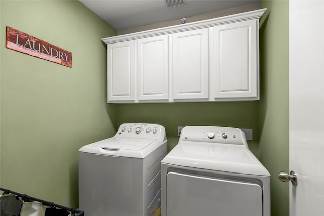 washroom with separate washer and dryer and cabinets