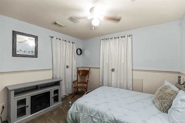 bedroom with ceiling fan and dark carpet