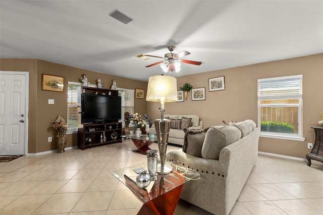 living room featuring ceiling fan, light tile patterned floors, and a wealth of natural light