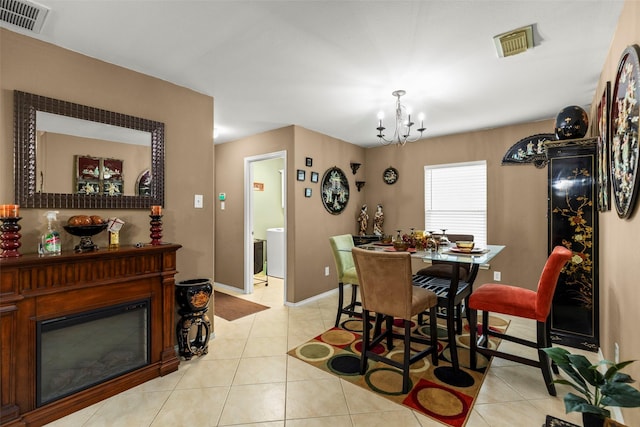 dining space with light tile patterned flooring and a chandelier