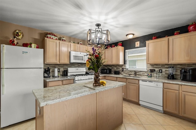 kitchen with white appliances, a chandelier, a center island, light tile patterned floors, and sink