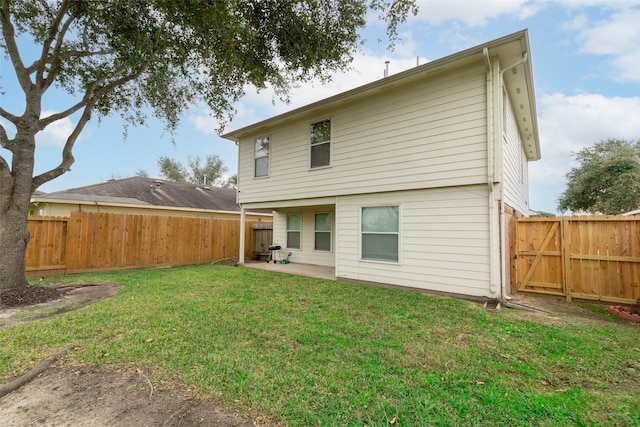 rear view of property featuring a patio area and a yard