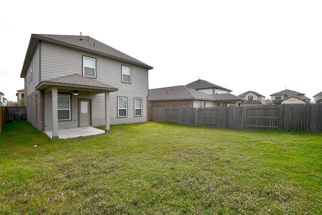 rear view of house featuring a lawn and a patio area