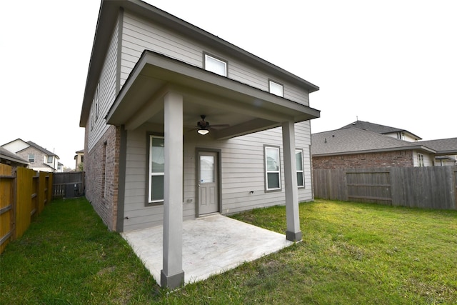 back of property with a lawn, ceiling fan, and a patio area