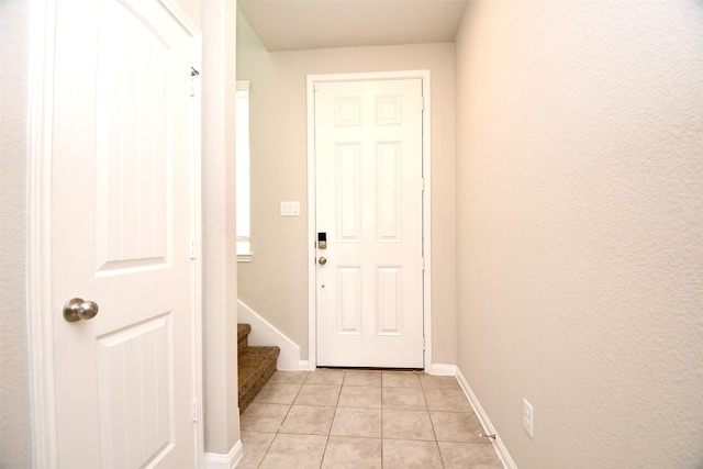 doorway to outside with light tile patterned floors