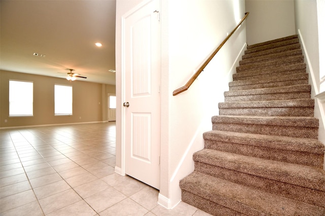 stairs featuring tile patterned floors and ceiling fan