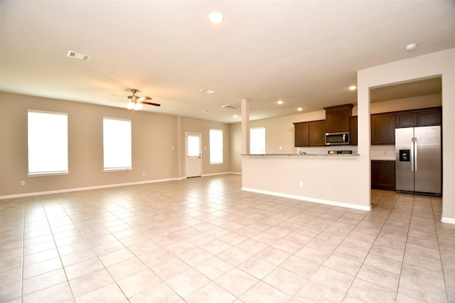 unfurnished living room featuring light tile patterned floors and ceiling fan