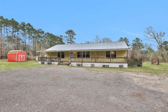 view of front of house with covered porch and a storage shed