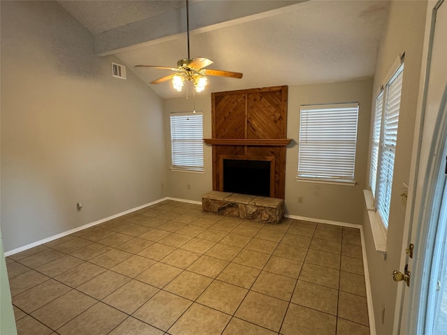 unfurnished living room featuring a fireplace, ceiling fan, light tile patterned flooring, and vaulted ceiling with beams