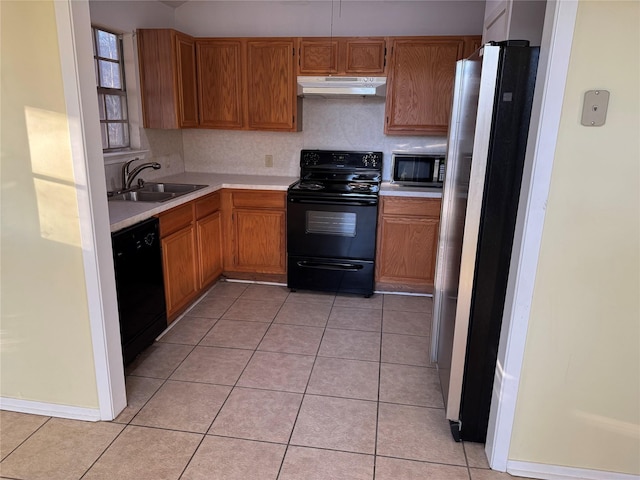 kitchen featuring light tile patterned floors, black appliances, tasteful backsplash, and sink