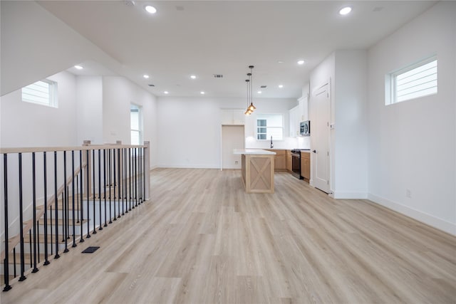 interior space with sink, a healthy amount of sunlight, and light wood-type flooring