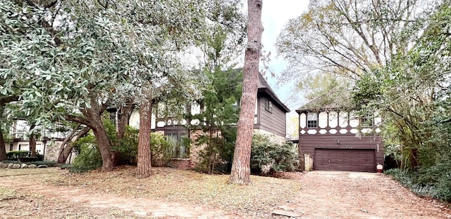 view of home's exterior featuring dirt driveway and an attached garage