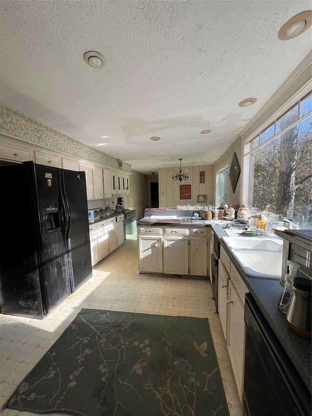 kitchen featuring white cabinetry, kitchen peninsula, a textured ceiling, and black appliances