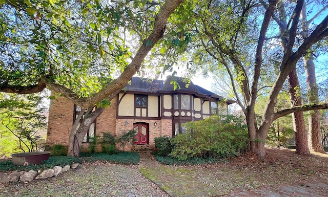 tudor-style house with brick siding and stucco siding