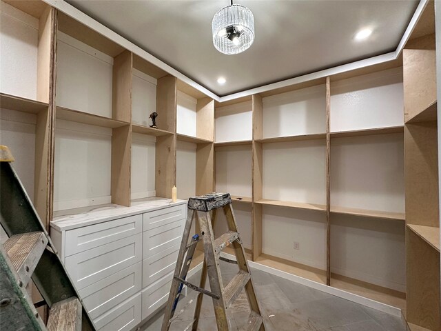 walk in closet with an inviting chandelier