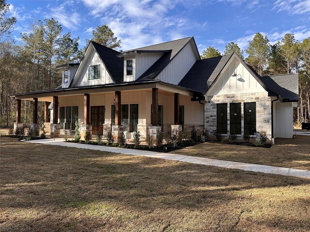 modern farmhouse style home with covered porch and a front yard